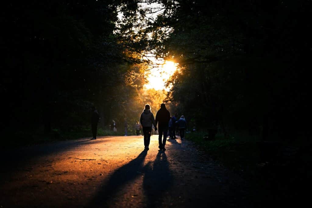 Ein Paar geht bei goldenem Sonnenuntergang durch einen Wald